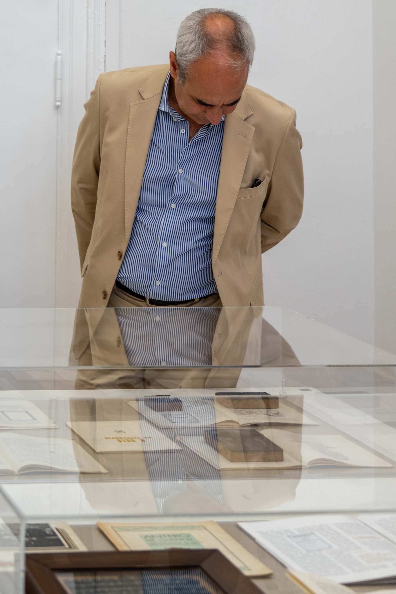 Visitante observa livros e documentos históricos numa vitrina